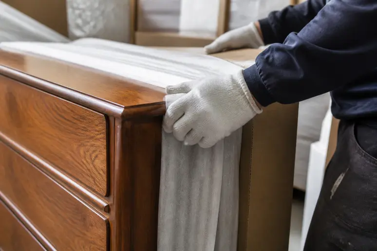 Emballage soigné d'un buffet vintage pamono par des professionnels pour une livraison sécurisée.