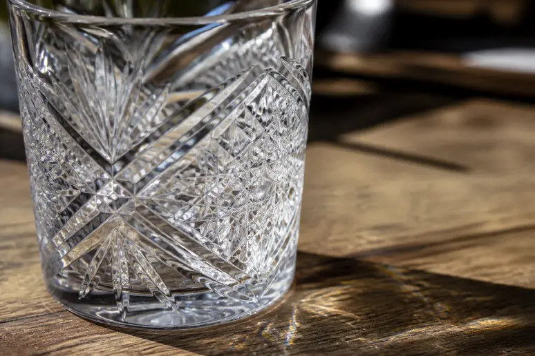 Détail de la gravure et des facettes d'un verre de Bohême captant la lumière naturelle