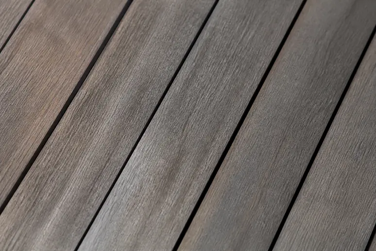Gros plan sur les lames de terrasse en ipé montrant le bois dense grisé par le temps