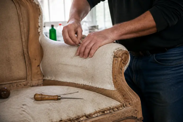 Artisan tapissier restaurant la garniture traditionnelle d'un fauteuil crapaud vintage