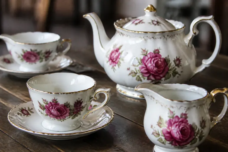 Service à thé en porcelaine de Sologne ancienne disposé sur une table en bois