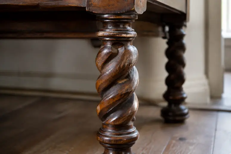 Gros plan sur le bois tourné et torsadé d'un meuble de style Louis XIII authentique.