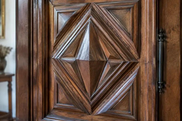 Façade d'armoire ancienne avec son décor en relief en pointe de diamant style Louis XIII.